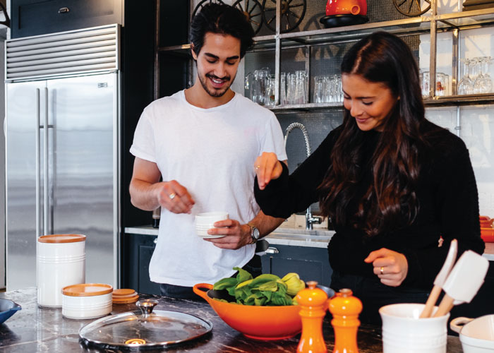 Photo of couple cooking a meal together in their kitchen