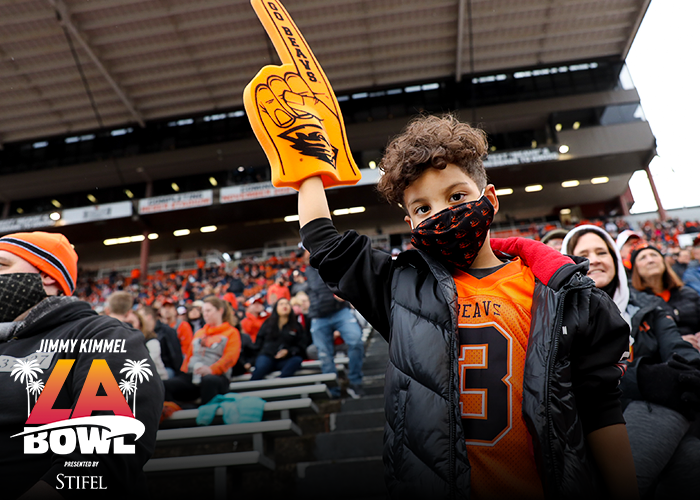 Child in Beaver gear holding up right arm that has a foam #1 finger on it while standing in Reser Stadium
