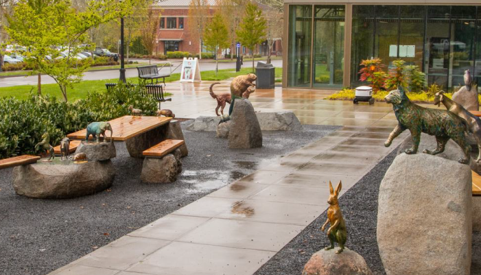 rainy sidewalk in front of Magruder flanked with broze statues of animals