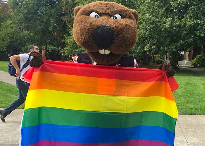 Photo of Benny Beaver holding a Pride Flag in the MU Quad