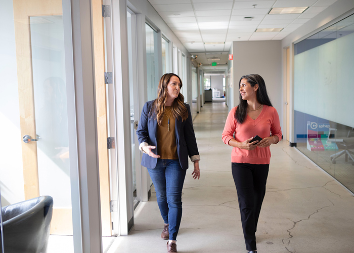 two coworkers walking through hall of a business