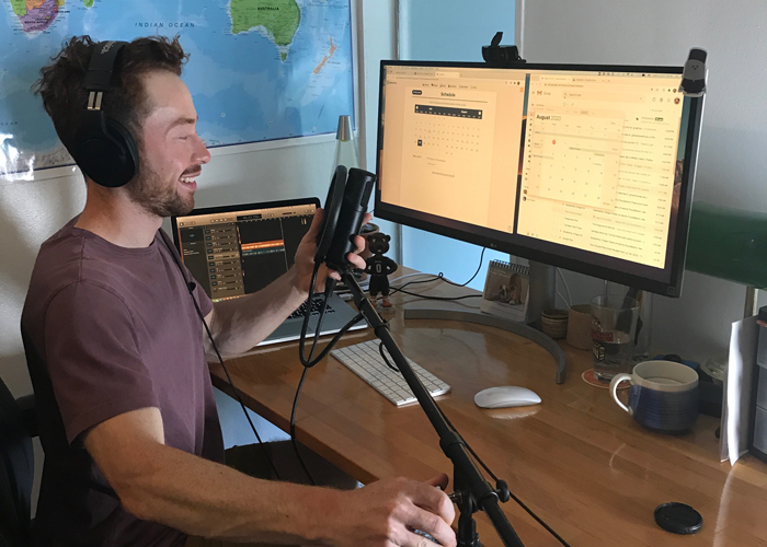 Cody Stover at his desk with his podcast set up ready to record