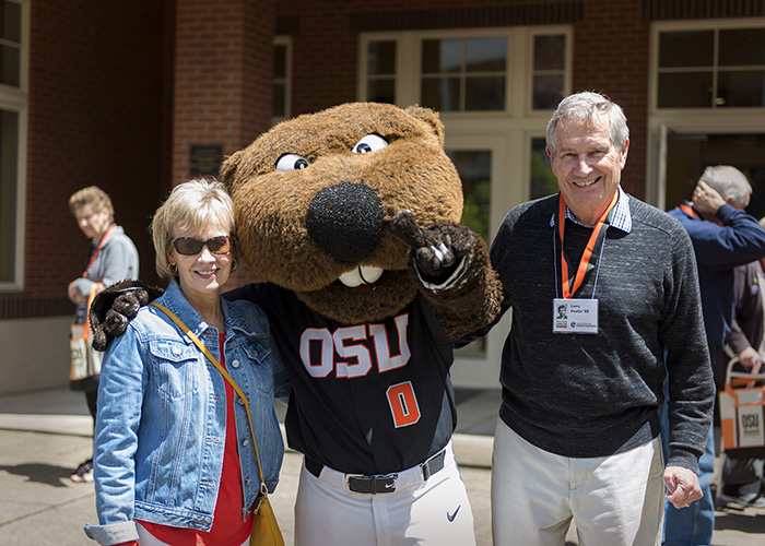 two reunion guests posing and smiling with Benny Beaver